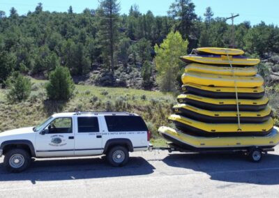Green river rafts on trailer ready to be launched into the river 2 miles from Dutch John Resort. Inflatable rubber Rafts in image seat 4-15 riders who paddle the raft through the cool clear waters surrounded by the 500-700 foot tall Red Canyon walls bordering the river.