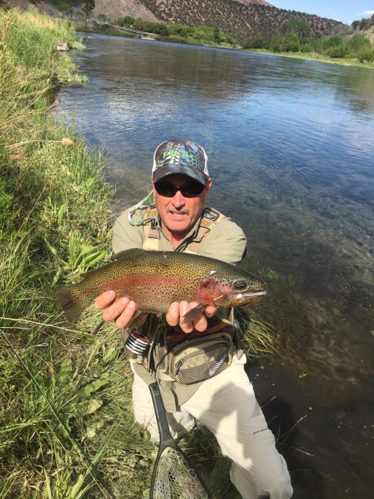 Green River Fishing Guide at Dutch John Resort Is Releasing Huge Beautiful Variegated Striped Rainbow Trout Into The Green River