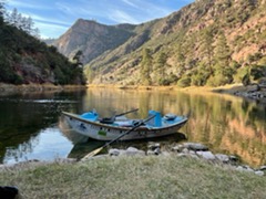 Drift boat on the Green river pulled into a calm eddie to allow Green river fishing guide and 2 fly fishing guests to stretch their legs on the shore & to cast dry flies to trophy size trout swimming in the Gin Clear waters of the Green river feeding on a hatch of Blue Wing Olive May Flies.