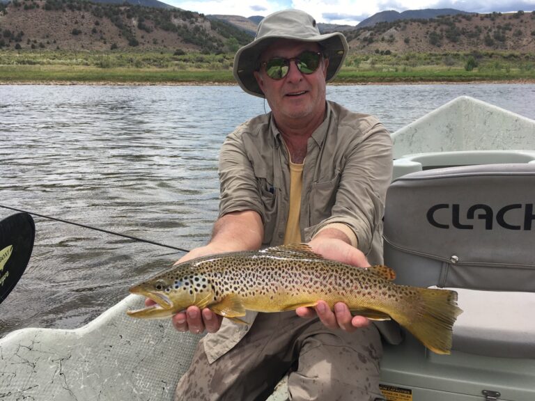 Drift Boat Fly fishing guest of Dutch John Resort Fishing Guides releasing large green river wild trout into the tail waters below Flaming Gorge Dam into the Green River