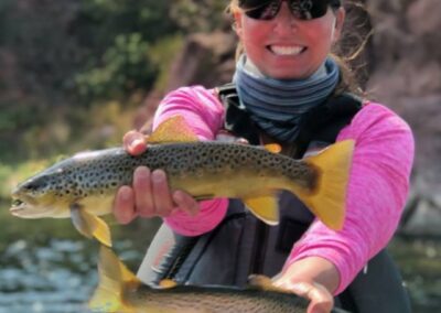 Fly-fishing guest of green river fly-fishing guides at Dutch John Resort releasing two wild brown trout back into their native waters of the Green river fishing from a 3 person drift boat from Dutch John Resort