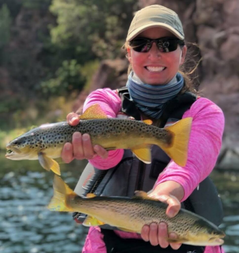 Fly-fishing guest of green river fly-fishing guides at Dutch John Resort releasing two wild brown trout back into their native waters of the Green river fishing from a 3 person drift boat from Dutch John Resort