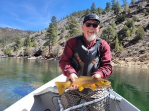 Drift Boat Fly fishing guest of Dutch John Resort Fishing Guides releasing large green river wild trout into the tail waters below Flaming Gorge Dam into the Green River 