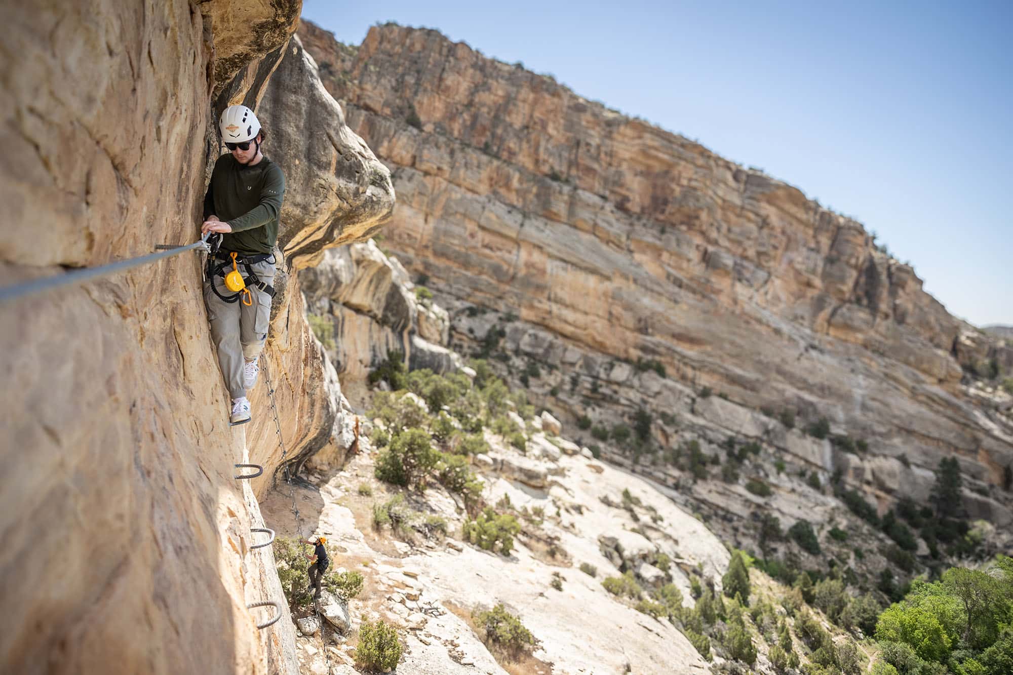 Climber on the Ashley Gorge Via Ferrata cable route above the canyon floor near Vernal, Utah